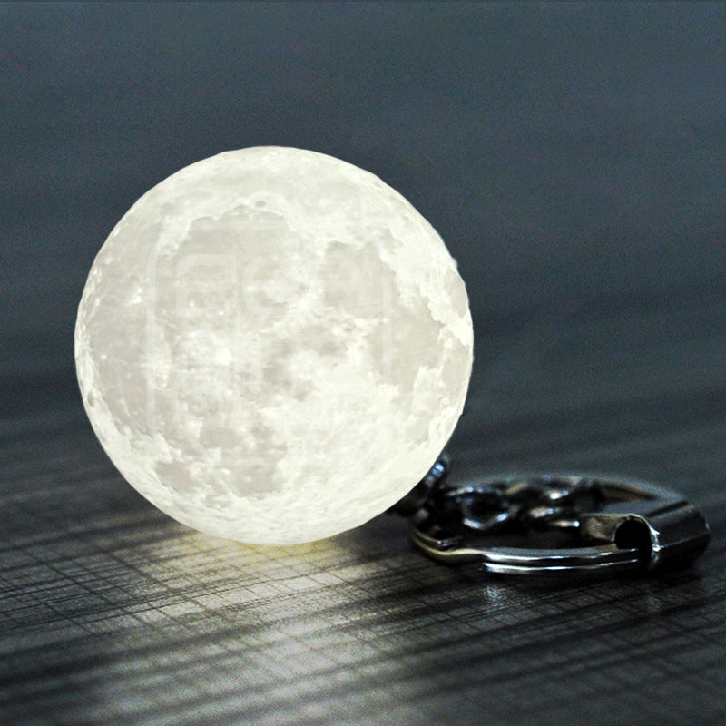 Mini moon lamp keychain glowing white light on dark background modern night light accessory